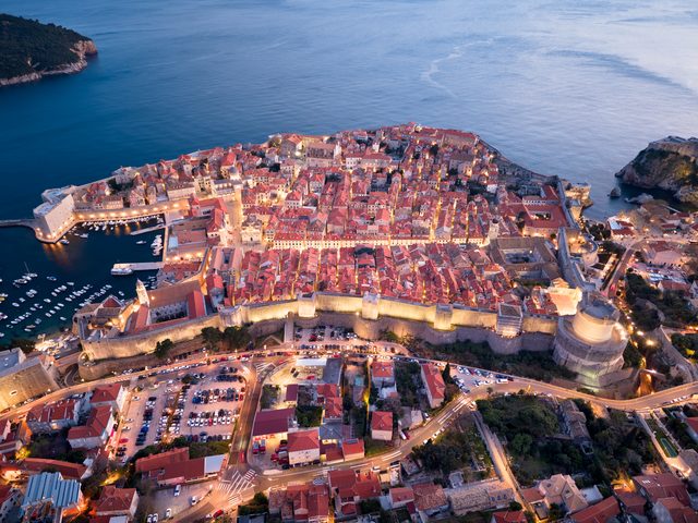 Alacakaranlıkta havadan Dubrovnik eski şehri, surları ve limanı