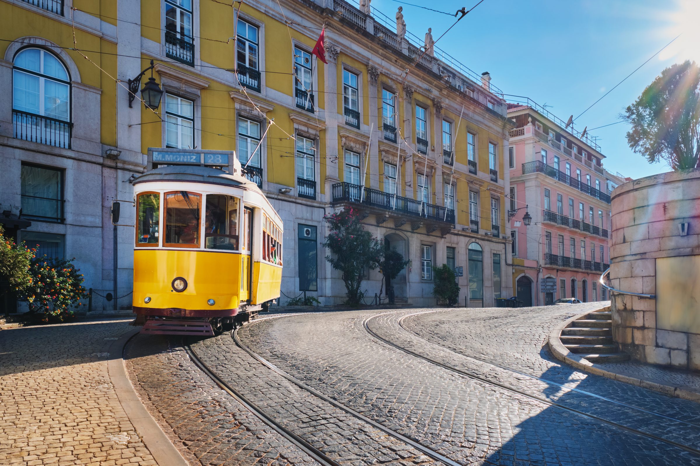 Lisbon’s yellow tram 28 on a cobblestone street